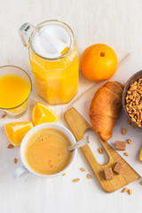 Breakfast concept - orange juice, croissant and coffee on a whit