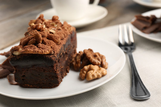 A piece of chocolate cake with walnut on the table, close-up