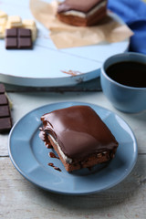 Delicious chocolate brownie on plate on wooden background