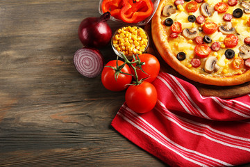 Delicious pizza with vegetables, meat on red napkin, close-up