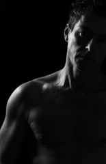 Fototapeta premium Uomo affascinante a torso nudo. Ritratto Low key in bianco e nero