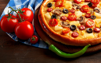 Delicious pizza with vegetables and meat on blue napkin, close-up