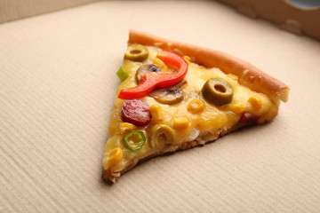 Slice of delicious pizza on cardboard