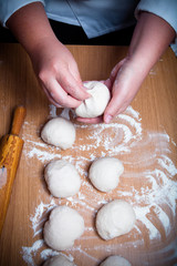 Female hands cut up dough. Selective focus. Toned