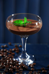 Chocolate dessert in glass on color wooden background