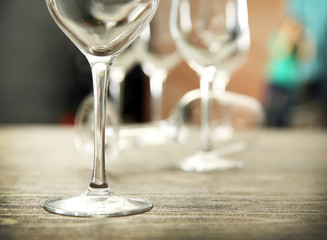 Empty wine glasses on wooden table against blurred background
