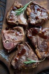 Closeup of grilled T-bone lamb steaks with sauce, studio shot