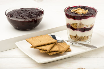 Healthy dessert with natural yogurt, full grain biscuits and black currant jam.