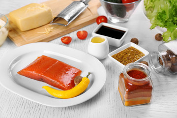 Kitchen utensils and ingredients for salad on table, on light background