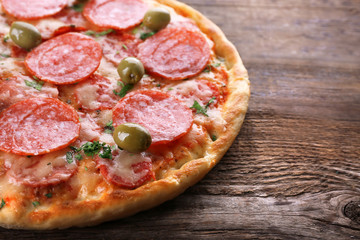 Delicious tasty pizza on wooden background