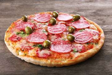 Delicious tasty pizza on wooden background