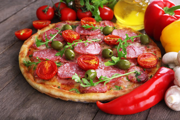 Delicious tasty pizza with ingredients on table, closeup