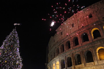 Obraz premium New year Eve in Rome, Fireworks at colosseum with a Christmas tree on its side