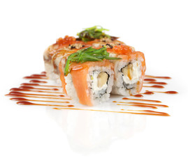 Sushi rolls with banana and salmon on white