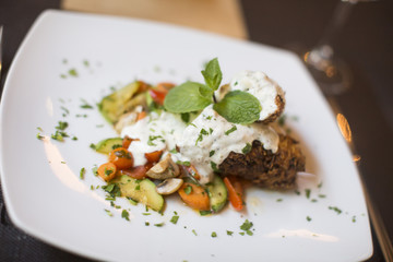 Grilled meat with sauce and herbs served at restaurant