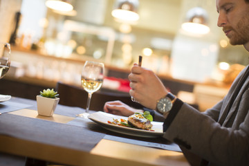 Man eating grilled salmon at restaurant