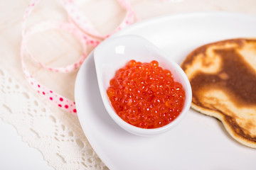 Pancake with red caviar serving celebratory close-up