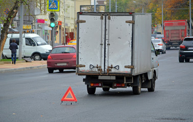 Сломавшийся на середине дороги грузовой фургон с выставленным знаком аварийной остановки