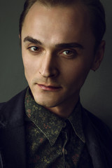 Fototapeta premium Portrait of one young handsome man looking forward in studio