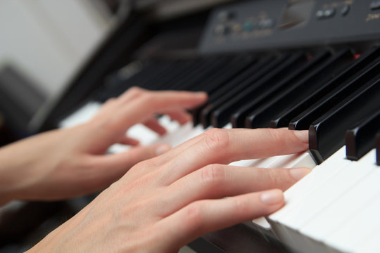 Close up of woman hands playing the piano