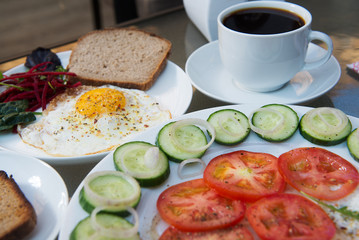 Coffee cup, scrambled eggs and salad breakfast on table