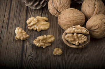 Walnut kernels and whole walnuts on rustic old wooden table