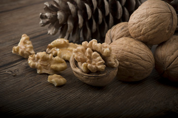 Walnut kernels and whole walnuts on rustic old wooden table