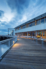Naklejka premium empty wooden footpath front of architecture at dusk