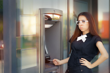 Fototapeta na wymiar Stressed Woman with credit card at ATM