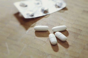 Fototapeta na wymiar White pills medicine close up on a wooden background