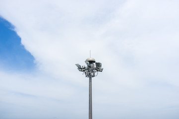 Spotlight pole with blue sky and white cloud background
