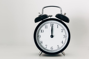 Black alarm clock showing 12 o'clock