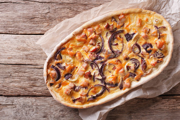 Tarte flambee on a paper. Horizontal top view
