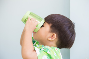 thristy asian boy drinking by hold up the cup