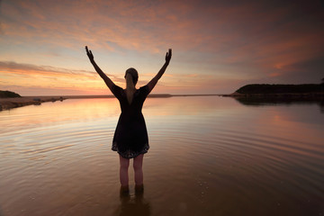Woman outstretched arms praising perfect day success