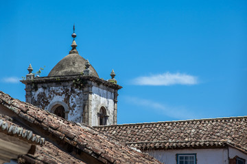 Fototapeta na wymiar Ancient roofs with an old church tower in the background - Parat