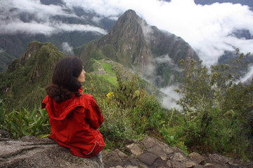 female in red jacket looking down Machu Picchu