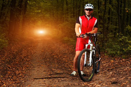 Man Cyclist Riding on bicycle in the Summer Forest