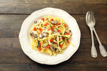 vista dall'alto Pasta italiana con verdure e pomodoro su sfondo legno rustico