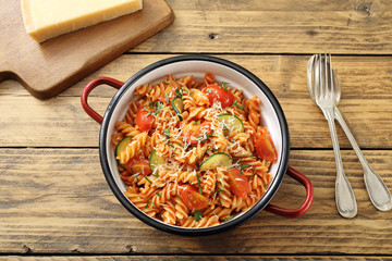 vista dall'alto Pasta italiana con zucchini e pomodoro su sfondo legno rustico