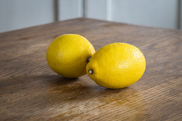 Two lemons in a wooden table with white background