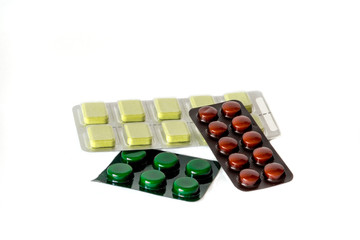 Pile different colors pills blister on white background