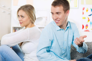 Obraz premium Young woman upset with her man turning her bank on him while he tries to explain