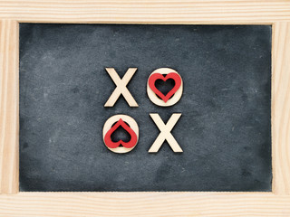 Wooden frame vintage chalkboard with text XOXO (kisses & hugs) created of wood letters
