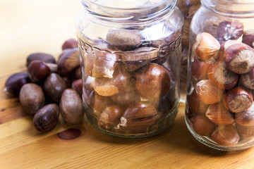 Nuts on glass jars over wooden surface