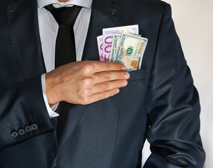 Caucasian male in suit holding lots of money in his pocket