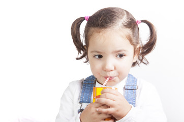 Portrait of happy girl drinking a brick fruit juice
