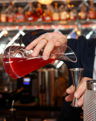 Bartender is pouring juice to measuring glass