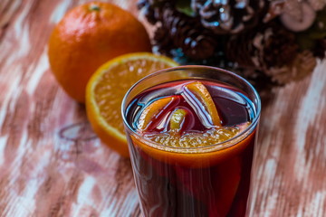Mulled wine on wooden table with Christmas background