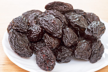 Pile of prunes on a white plate